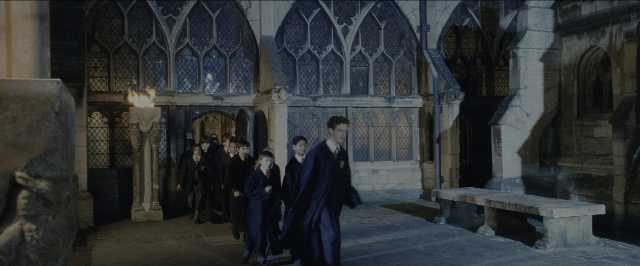 Wide shot frame from Harry Potter and the Sorcerer's Stone — walking, suit, tie