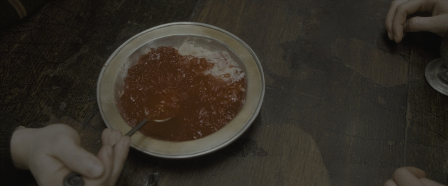 Wide shot frame from Harry Potter and the Half-Blood Prince — table, kitchen, human hand