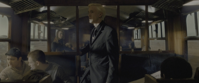 Wide shot frame from Harry Potter and the Half-Blood Prince — sitting, standing, car