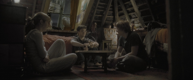 Wide shot frame from Harry Potter and the Half-Blood Prince — sitting, book, room