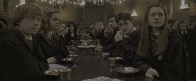 Wide shot frame from Harry Potter and the Half-Blood Prince — sitting, room, table