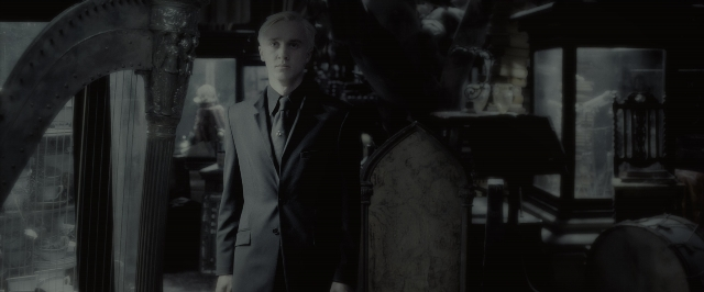 Wide shot frame from Harry Potter and the Half-Blood Prince — standing, room, suit