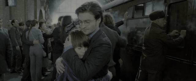 Medium shot frame from Harry Potter and the Deathly Hallows - Part 2 — standing, kiss, suit