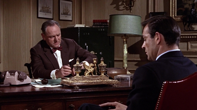 Wide shot frame from From Russia with Love — sitting, desk, phone
