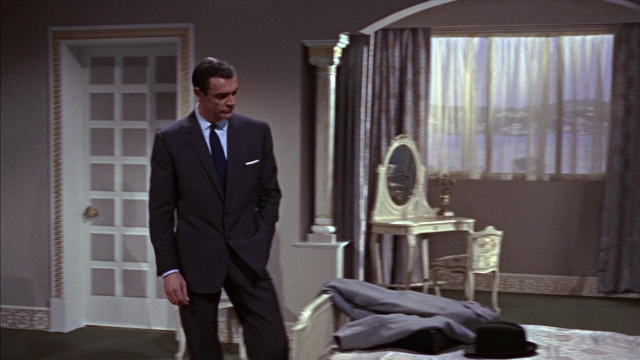 Wide shot frame from From Russia with Love — standing, room, bed