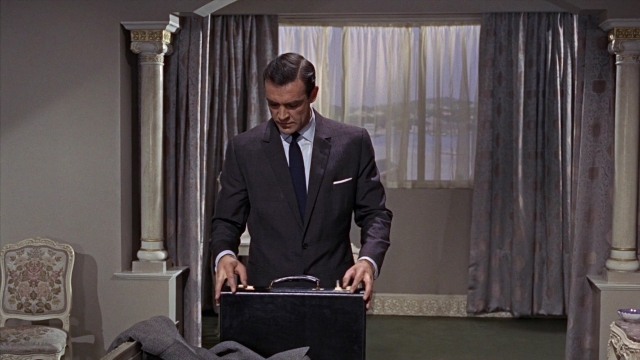 Wide shot frame from From Russia with Love — standing, room, table
