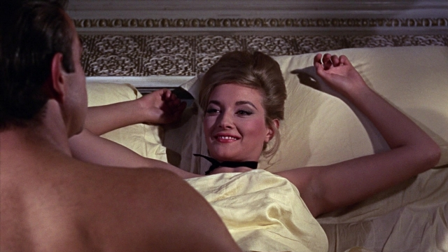 Wide shot frame from From Russia with Love — standing, bed, dress