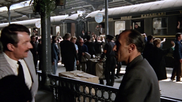 Wide shot frame from From Russia with Love — standing, dialogue, suit
