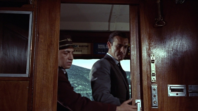 Wide shot frame from From Russia with Love — standing, door, hat