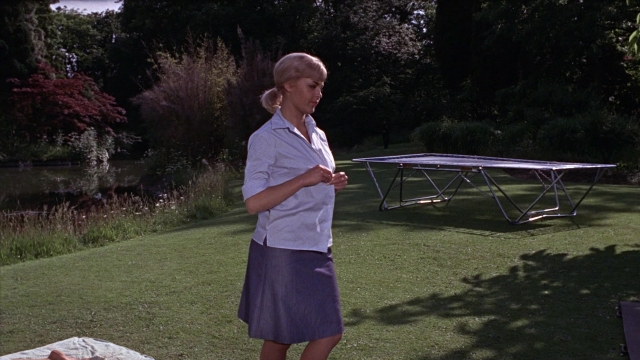 Wide shot frame from From Russia with Love — standing, table, hand
