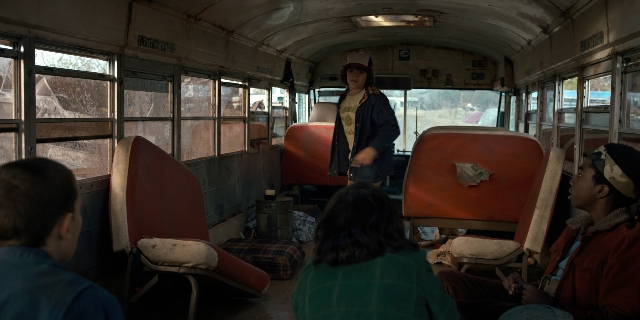 Wide shot frame from Stranger Things — sitting, standing, dialogue