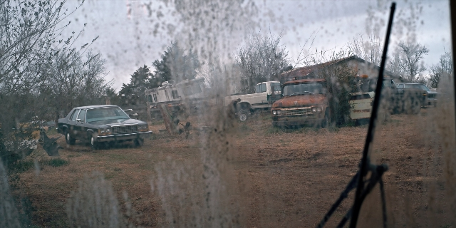 Wide shot frame from Stranger Things — car, truck, wheel