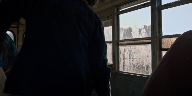 Wide shot frame from Stranger Things — standing, glass, person