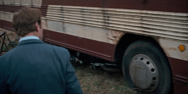 Frame from Stranger Things — standing, suit, bus