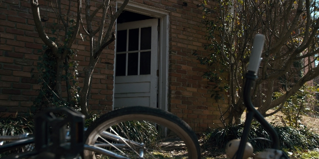 Wide shot frame from Stranger Things — door, house, bicycle