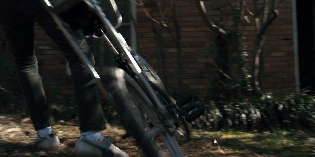 Wide shot frame from Stranger Things — person, footwear, bicycle wheel