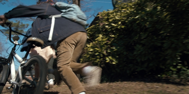 Wide shot frame from Stranger Things — bicycle, person, footwear
