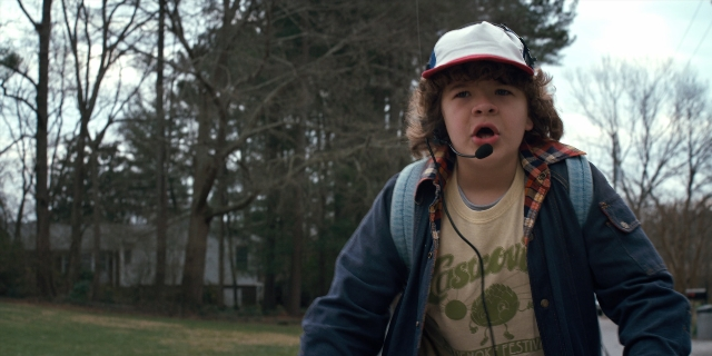Wide shot frame from Stranger Things — standing, hat, shirt