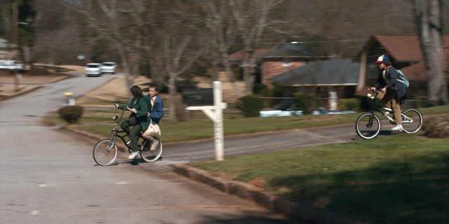 Wide shot frame from Stranger Things — standing, street, hat