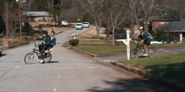 Wide shot frame from Stranger Things — street, bicycle, person