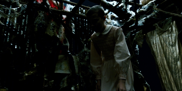 Wide shot frame from Stranger Things — standing, room, dress