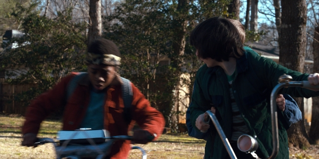 Wide shot frame from Stranger Things — standing, dialogue, hat