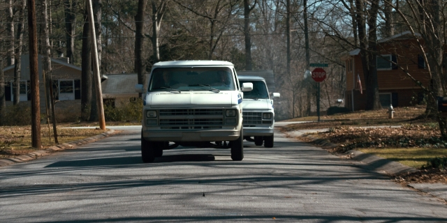 Wide shot frame from Stranger Things — street, truck, wheel
