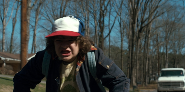 Wide shot frame from Stranger Things — standing, hat, face