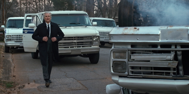 Wide shot frame from Stranger Things — walking, street, suit