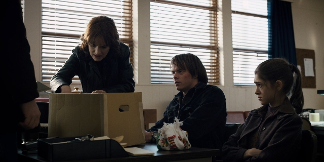 Wide shot frame from Stranger Things — sitting, standing, room