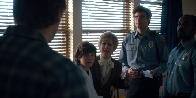 Wide shot frame from Stranger Things — standing, room, dialogue