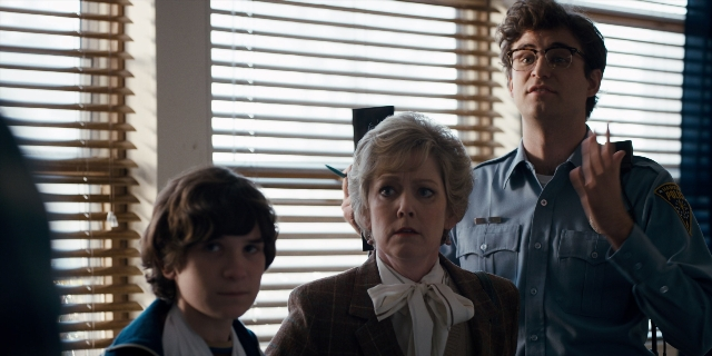 Wide shot frame from Stranger Things — standing, uniform, shirt