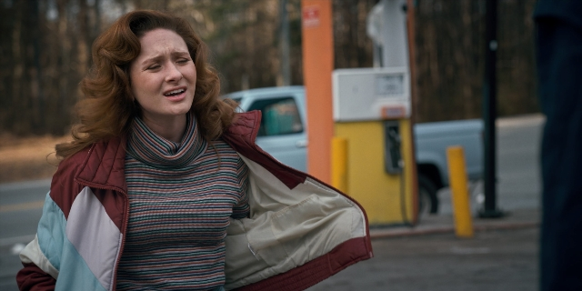 Wide shot frame from Stranger Things — standing, street, car