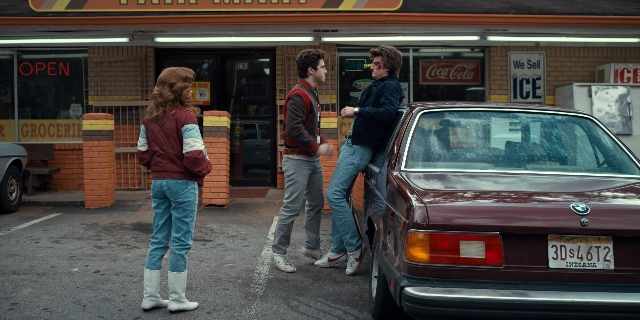 Wide shot frame from Stranger Things — sitting, standing, dialogue