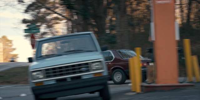 Wide shot frame from Stranger Things — street, car, truck