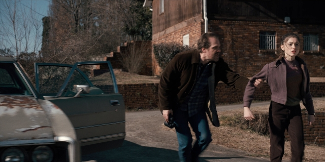 Wide shot frame from Stranger Things — walking, door, street
