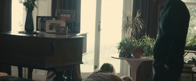 Wide shot frame from About Time — standing, room, table