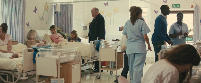 Wide shot frame from About Time — sitting, standing, room