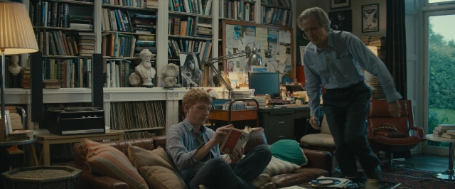 Wide shot frame from About Time — sitting, book, standing