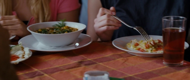 Wide shot frame from Kak menya zovut — sitting, plate, table