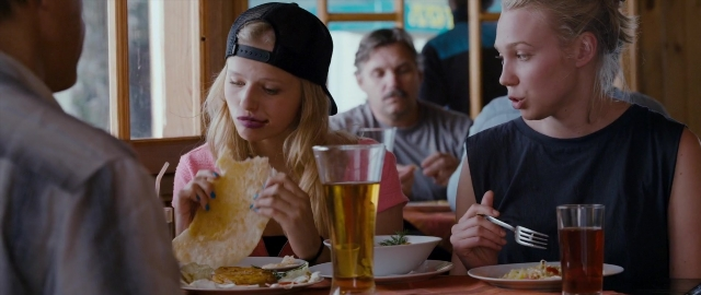 Wide shot frame from Kak menya zovut — sitting, table, hat