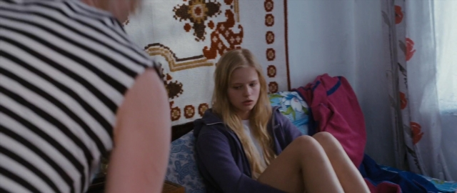 Wide shot frame from Kak menya zovut — sitting, bed, shirt