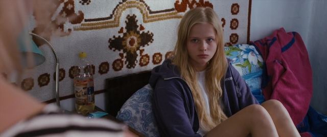 Wide shot frame from Kak menya zovut — sitting, bed, hand