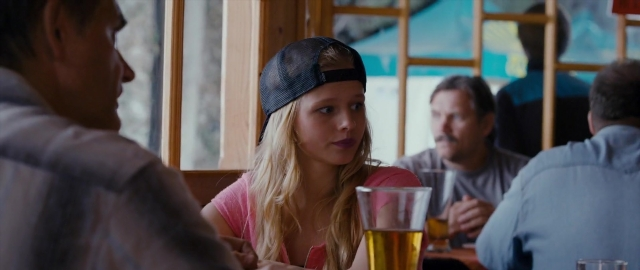 Wide shot frame from Kak menya zovut — sitting, table, hat