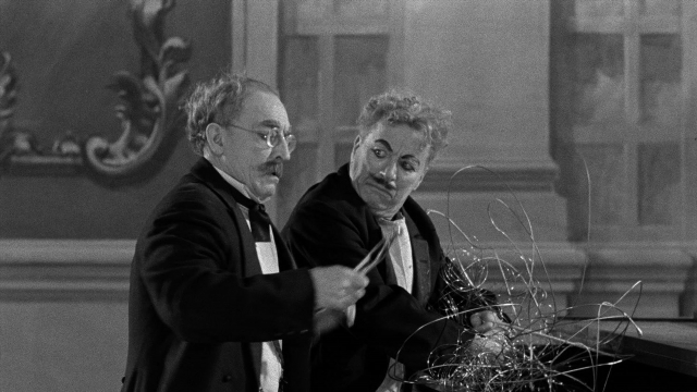 Wide shot frame from Limelight — standing, room, hand