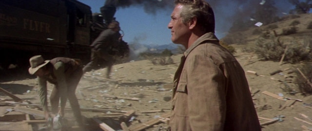 Wide shot frame from Butch Cassidy and the Sundance Kid — standing, street, train