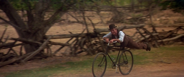 Wide shot frame from Butch Cassidy and the Sundance Kid — street, hat, bicycle