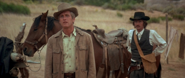 Wide shot frame from Butch Cassidy and the Sundance Kid — standing, hat, coat