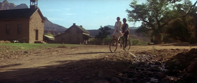 Wide shot frame from Butch Cassidy and the Sundance Kid — street, house, bicycle