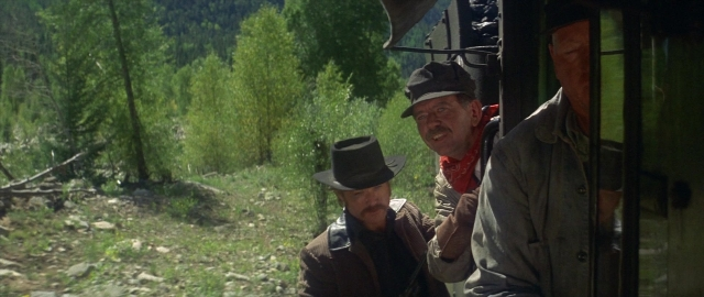 Wide shot frame from Butch Cassidy and the Sundance Kid — standing, gun, train